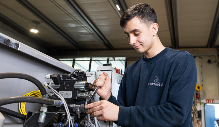 Lehrling bei der Montage einer Hydraulikanlage