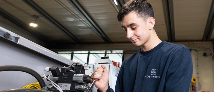 Lehrling bei der Montage einer Hydraulikanlage